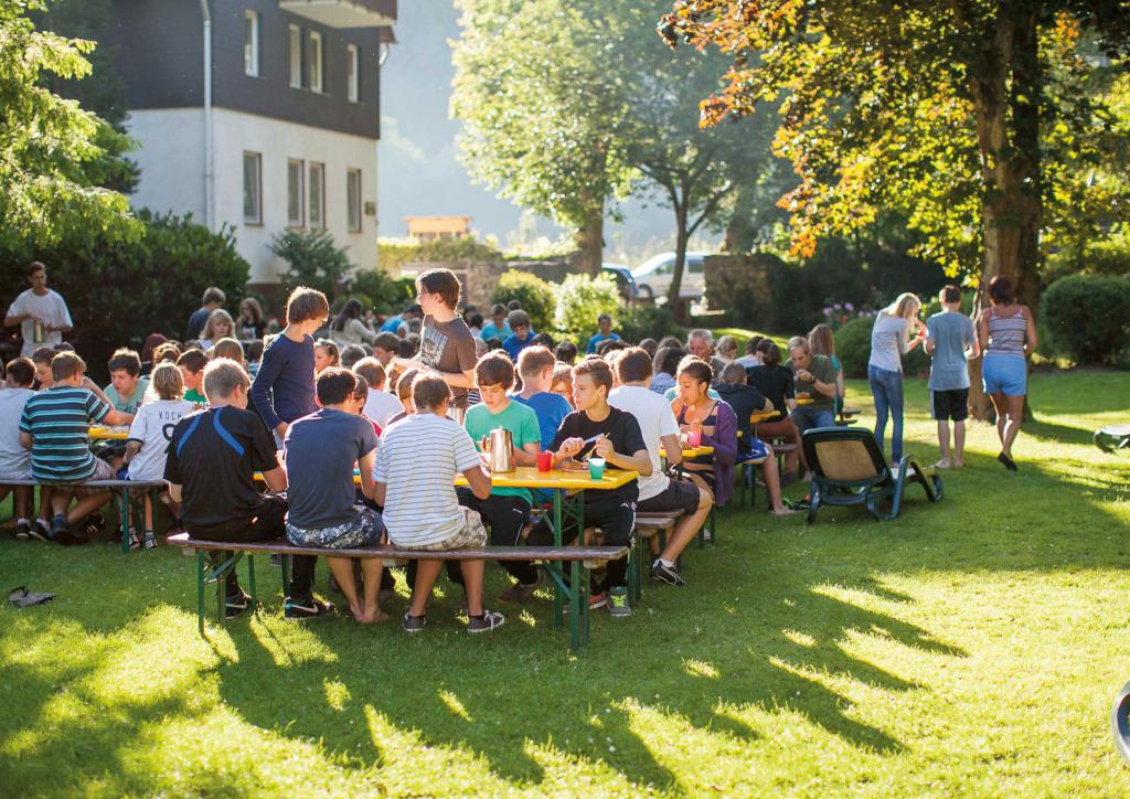 Eine Gruppe des biblischen Unterrichts isst im Garten der Klostermühle